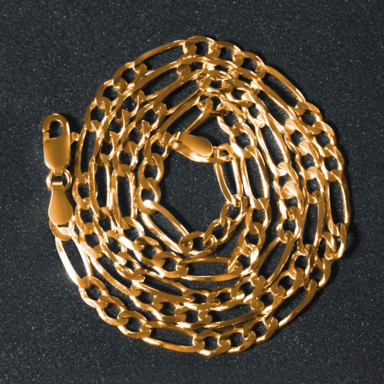 14K yellow gold solid Figaro chain, 3.80mm, wrapped in a circular coil to highlight polished long‑and‑short links and solid gold craftsmanship.