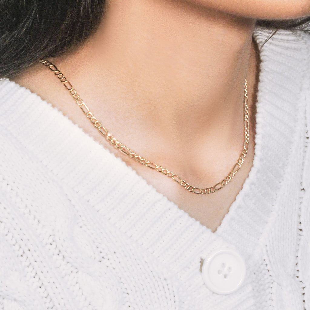 Texture detail of 10K yellow gold Figaro chain, 3.70mm, showing smooth, polished surface and link curvature.