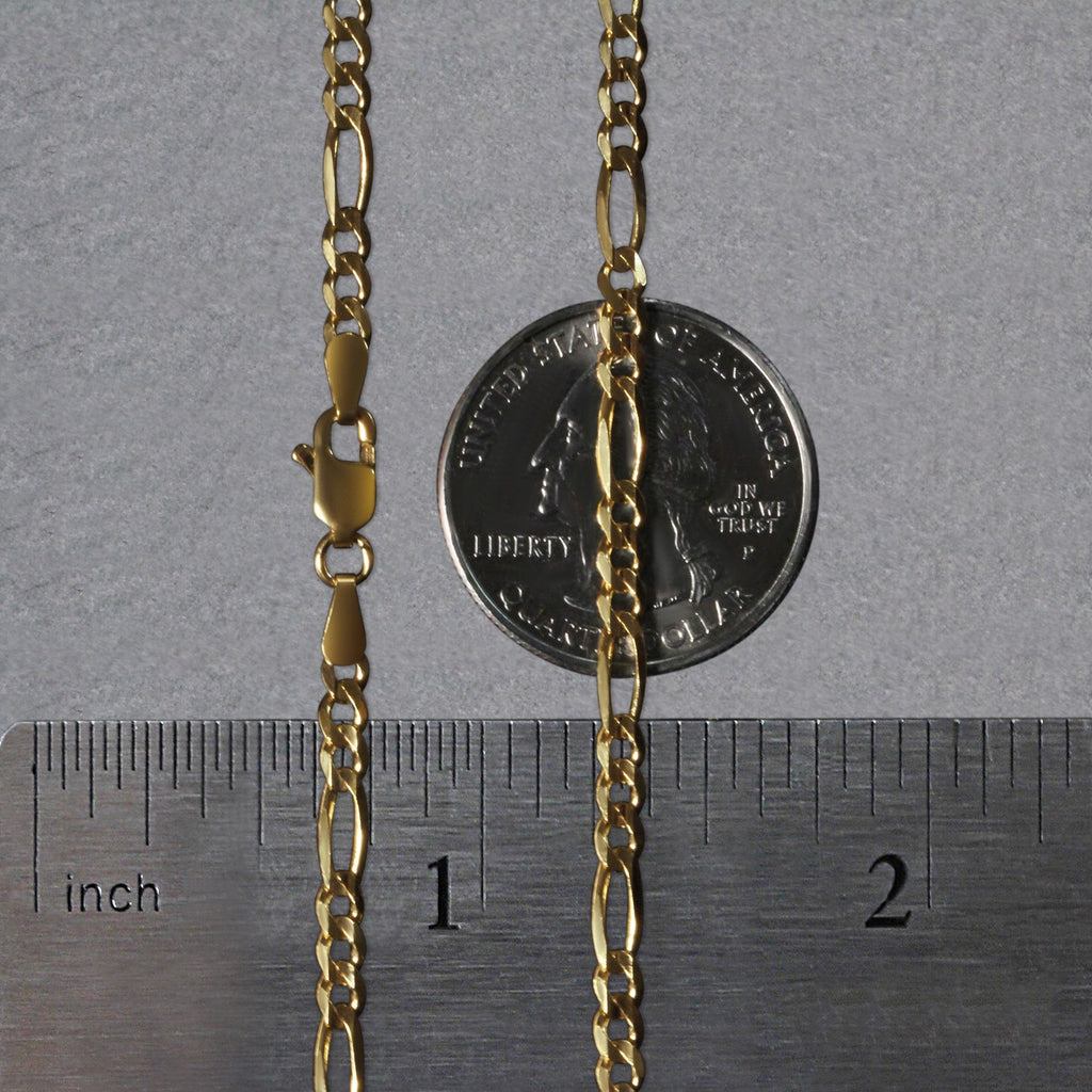 10K yellow gold solid Figaro chain, 2.60mm, shown flat on a quarter and ruler to display true scale and polished link detail.